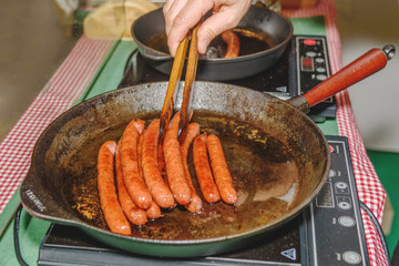 Sausages are fried in frying pan