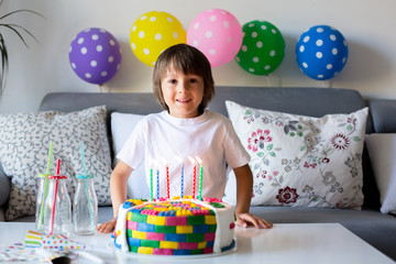 Sweet little child, boy, celebrating his sixth birthday, cake, balloons, candles, cookies.