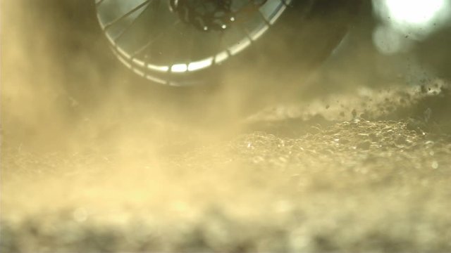 Motocross tire spinning out in the dirt and rocks in slow motion