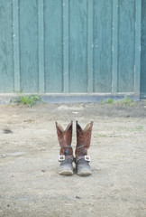 Leather cowboy/cowgirl boots by a barn 