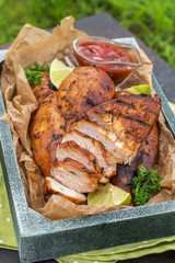 Grilled chicken breast served with herbs and lime