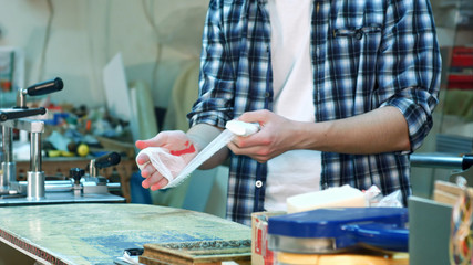 Worker injured hand, laying a bandage on the wound