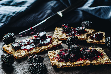 Whole grain bread crackers with jam and blackberries