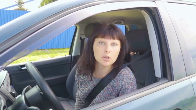 Young angry woman in perplexity sitting in the car.
