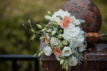 A wedding bouquet lies on a stone fence