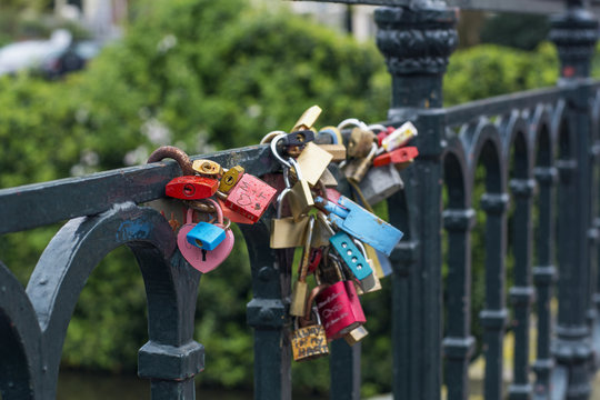 Many love locks are on the modern bridge in Amsterdam (the Netherlands, Europe)