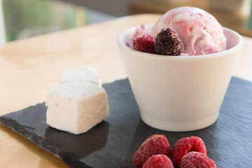 The ice cream with berries marshmallow and mint on the slate