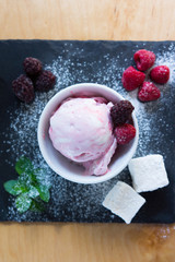The white-pink ice cream with sugar powder berries on the slate