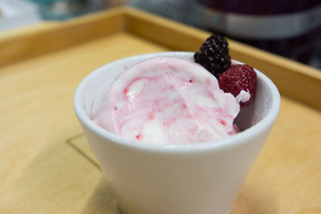 The white-pink ice cream with berries on the table