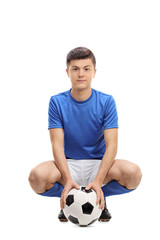 Teenage soccer player with a football