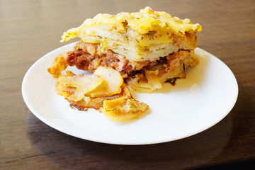 potato casserole with Turkey meat in a white plate.