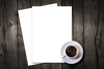 Blank letterhead and coffee cup on vintage wooden table background.