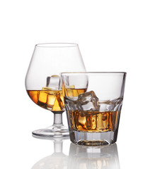 Two glasses of strong alcoholic drink scotch whiskey with ice cube