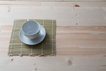 Fototapeta na wymiar one pure white ceramic Cup and saucer stands on a wooden table
