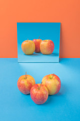 Apple on blue table isolated over orange background