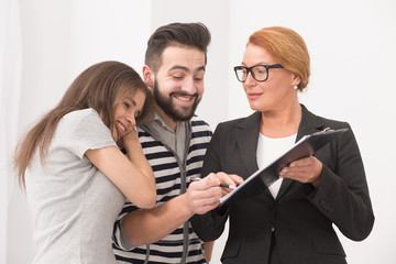 Swindler cheats good natured man and woman. Happy couple and tricky estate agent insisting on signing up the contract.