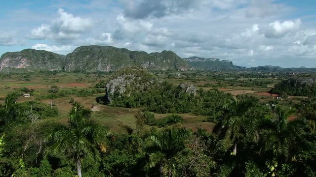 Elevated pan from right to left of Vinales Valley National Park in Cuba. Sierra de los Órganos mountains on the background
