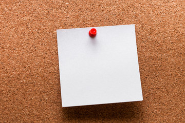 White paper with red clip nailed on wooden board