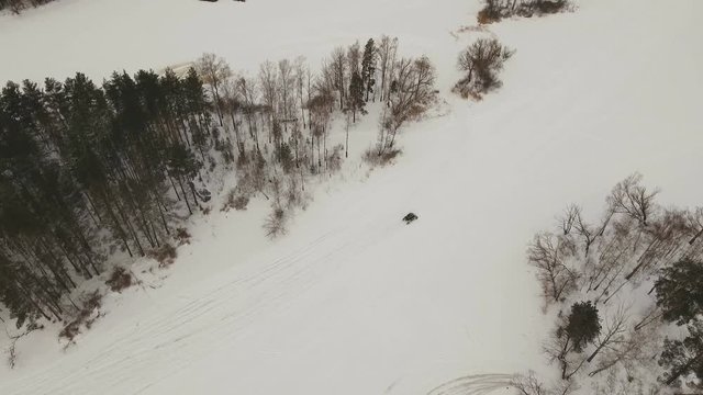 Winter off-road racing side-by-side vehicles. Aerial view: Rally on the buggy on the snow on a winter day. Racing in the SXS class. Buggy, sports car on rally. Off Road Series racing. 4K video, drone