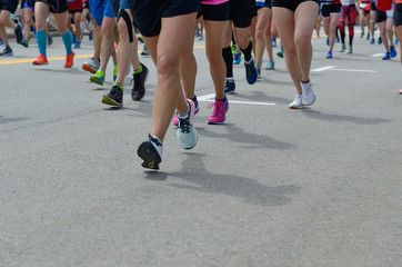Marathon running race, many runners feet on road, sport, fitness and healthy lifestyle concept
