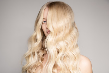 Portrait Of A Beautiful Young Blond Woman With Long Wavy Hair.