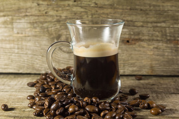 Cup and grain of coffee over wooden background