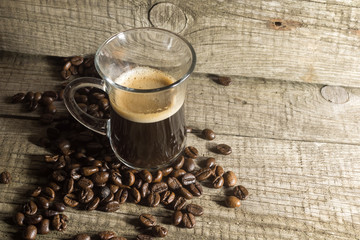 Cup and grain of coffee over wooden background