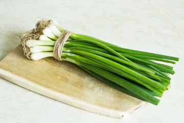 A bunch of fresh raw green onions on a wooden background. Country style. Selective focus. Top view. ©  Iryna	