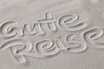 Gute Reise, in den Sand gemalter Text