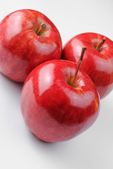 Three red apples on white background
