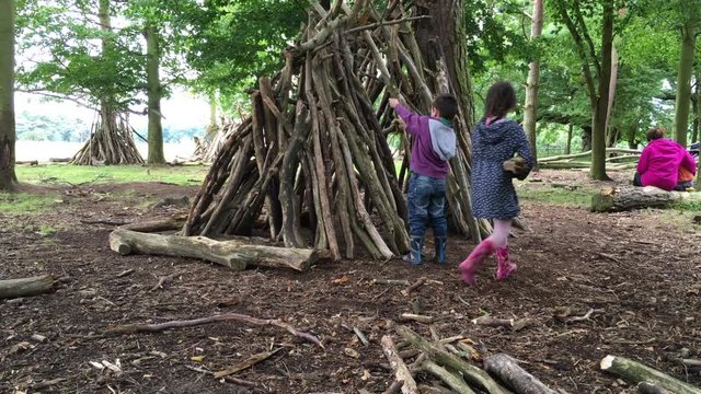 Young family making a den in woodland