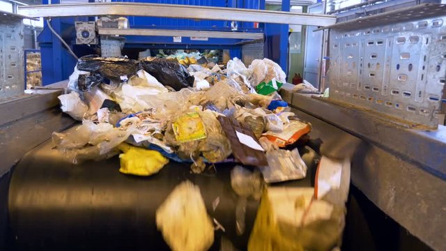 A large quantity of trash moving on a waste conveyor.