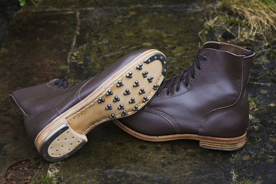Pair of brown leather work boots with studded sole, hobnail boots and heel from a shoemaker's workshop.