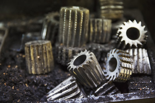 Close up of various shaped metal cogs and threads in a shoemaker's workshop.