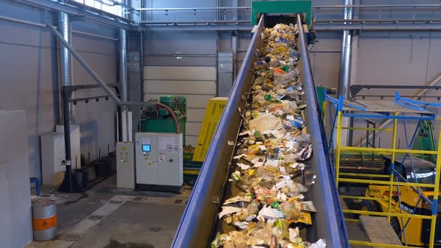 Trash being sorted at waste processing plant.