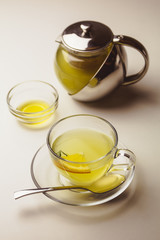 Herbal mint tea in a glass cup with lemon, the teapot and honey