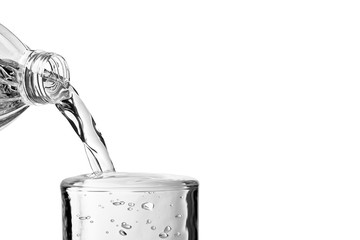 Pouring water over glass on white background with space for text, close-up