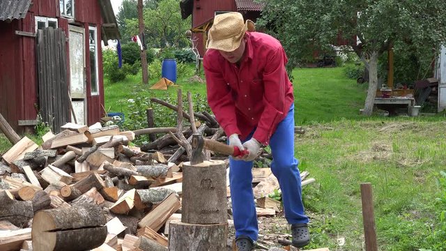 Villager guy with hat unsuccessful try to chop big wood log. 4K