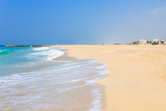 Panoramic view on nice Jumeirah beach in Dubai, UAE. United Arab Emirates famous tourist destination. Clear blue water Persian gulf, Indian Ocean