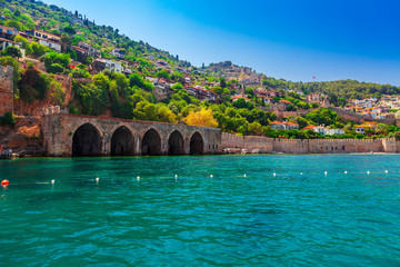 Naklejka premium Landscape of ancient shipyard near of Kizil Kule tower in Alanya peninsula, Antalya district, Turkey, Asia. Famous tourist destination with high mountains. Part of ancient old Castle. Summer day
