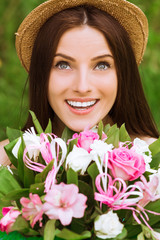 Portrait of young exquisite smiling woman who keeps bouquet of flowers outdoor