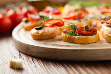 Crostini with different toppings on wooden background. Delicious appetizers. Front view.