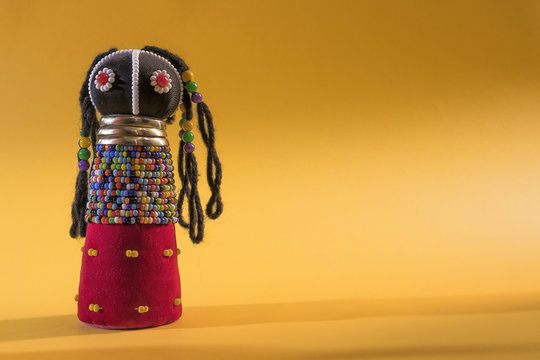 African cloth doll isolated on yellow background