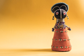 African cloth doll isolated on yellow background