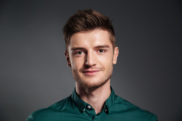Fototapeta premium Cheerful young man posing isolated over grey background
