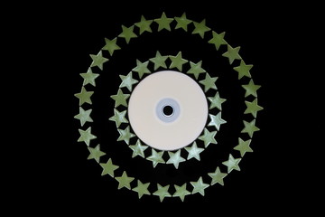 geometric circles of toy fluorescent glowing stars and CD disk in the center on a black background