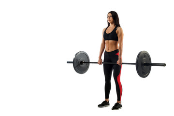 Young athletic woman doing deadlift with a barbell on a white isolated background, standing position, legs at shoulder level