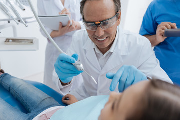 Portrait of competent dentist while repairing one problem in mouth