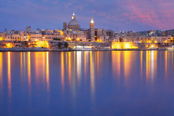 Obraz na płótnie Canvas Valletta Skyline from Sliema with church of Our Lady of Mount Carmel and St. Paul's Anglican Pro-Cathedral during evening blue hour, Valletta, Capital city of Malta