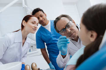 Attentive dentist doing teeth examination